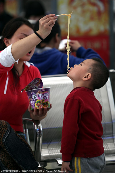 2013年1月22日。深圳北站。一位母亲正在喂孩子吃方便面。（IMG-3199-130122）