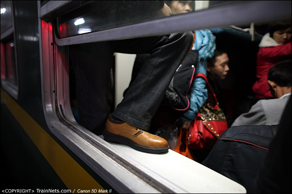 2013年1月28日。深圳西站。L6次深圳西-成都，一位卧代座的乘客因为拥挤，脚踏上了小桌板。（IMG-5281-130128）