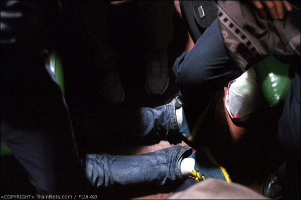 在最拥挤的12号车厢，一位乘客直接躺在座椅底下，露出两只脚。（D7416）