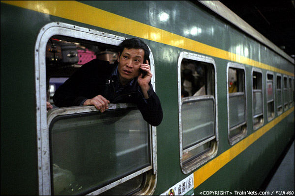 2013年1月30日。深圳站。凌晨，深圳开往成都的L76次列车，一位乘客探出头给同伴打电话。（D7513）