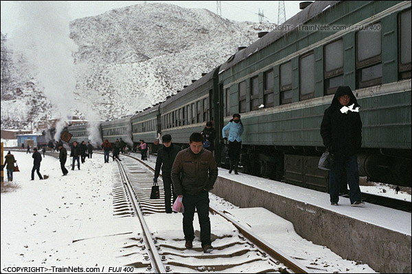 2014年2月。甘粛省の白銀鉱山鉄道、353番通勤車が三冶煉駅に到着した。出勤の労働者たちは簡易プラットホームから降りている。（E3702）