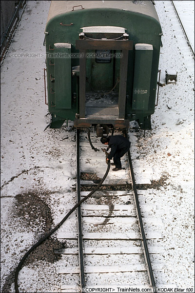 2014年2月。甘粛省白銀市の白銀鉱山鉄道。朝一番の山中に入るグリーン通勤車の牽引作業が終わった。その後、客車が車庫に牽引された。労働者は客車に暖房パイプを接続し、車両の温度を維持する。（E3819）