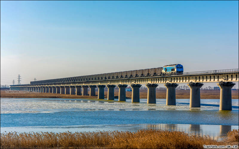 2016年1月7日。天津市大港区。神华铁路HXN3机车牵引货列上行通过黄万线大桥。（图/8K-135）