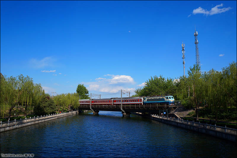2016年4月。北京。韶山8牵引全列红白25G的K473次（北京-昆明）跨越蓝天白云下的北京南护城河。（图/陈飞宇）