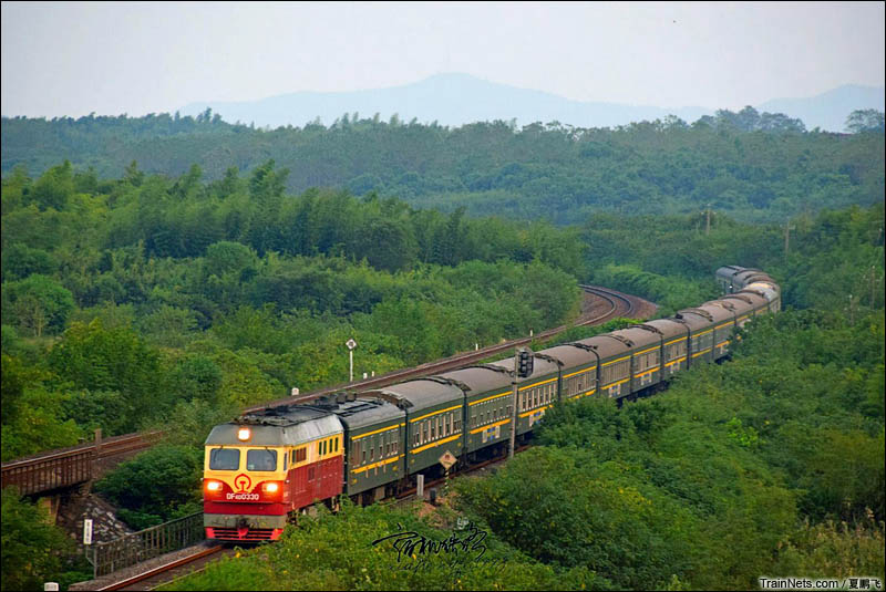 2016年10月9日。DF4D牵引K8382次（黄山-合肥）车底行驶在皖赣线上，万绿丛中一点红。（图/夏鹏飞）